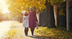 Mother and daughter walking in the street in the autumn