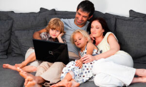Young family on a sofa with a laptop